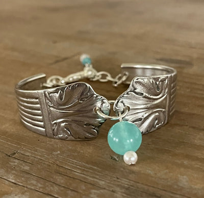 Close-up of Lady Esther spoon link bracelet showing bold scroll design with teal glass bead and pearl charm - handcrafted from upcycled vintage silverware - Laughing Frog Studio