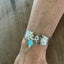 Lady Esther spoon link bracelet worn on wrist showing Art Deco design and teal glass bead charm with pearl drop - handcrafted from upcycled vintage silverware - Laughing Frog Studio