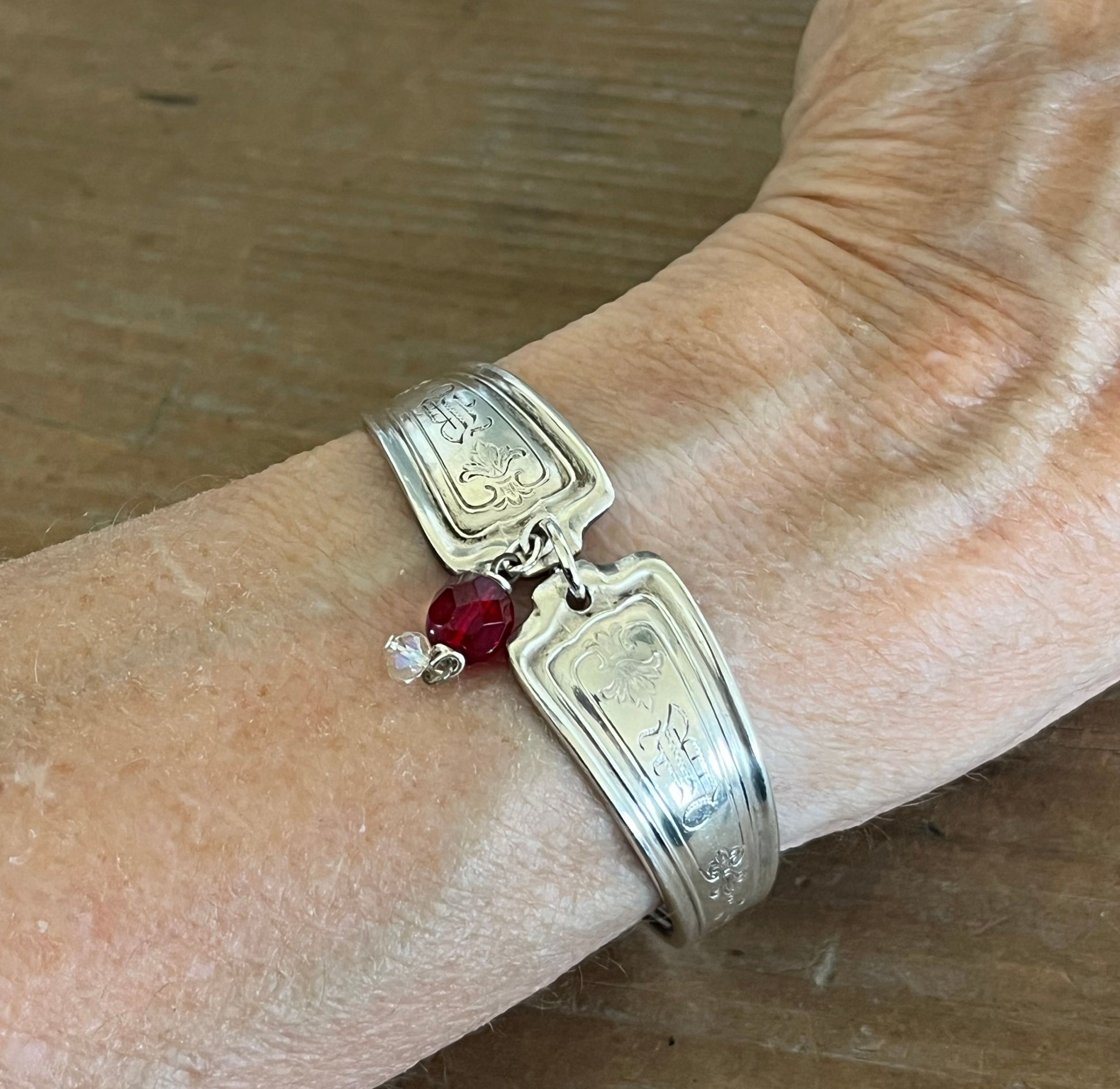 Louvain spoon link bracelet worn on wrist showing fit and red bead charm - handcrafted from upcycled vintage silverware - Laughing Frog Studio