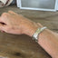 Worn on wrist top view - Mermaid Soul Troy pattern spoon cuff bracelet - handcrafted from upcycled vintage silverware - Laughing Frog Studio