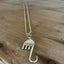 Fork elephant necklace with Hamsa hand charm on wood background - upcycled silverplate pendant necklace - handcrafted from upcycled vintage silverware - Laughing Frog Studio