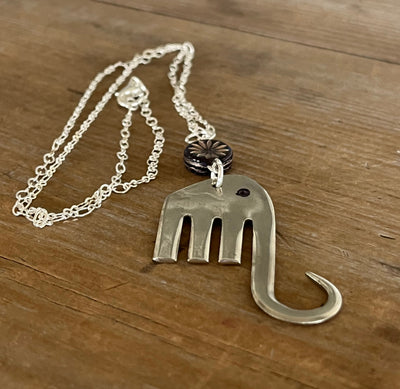 Close-up of fork elephant necklace with purple floral glass bead showing pendant detail - handcrafted from upcycled vintage silverware - Laughing Frog Studio