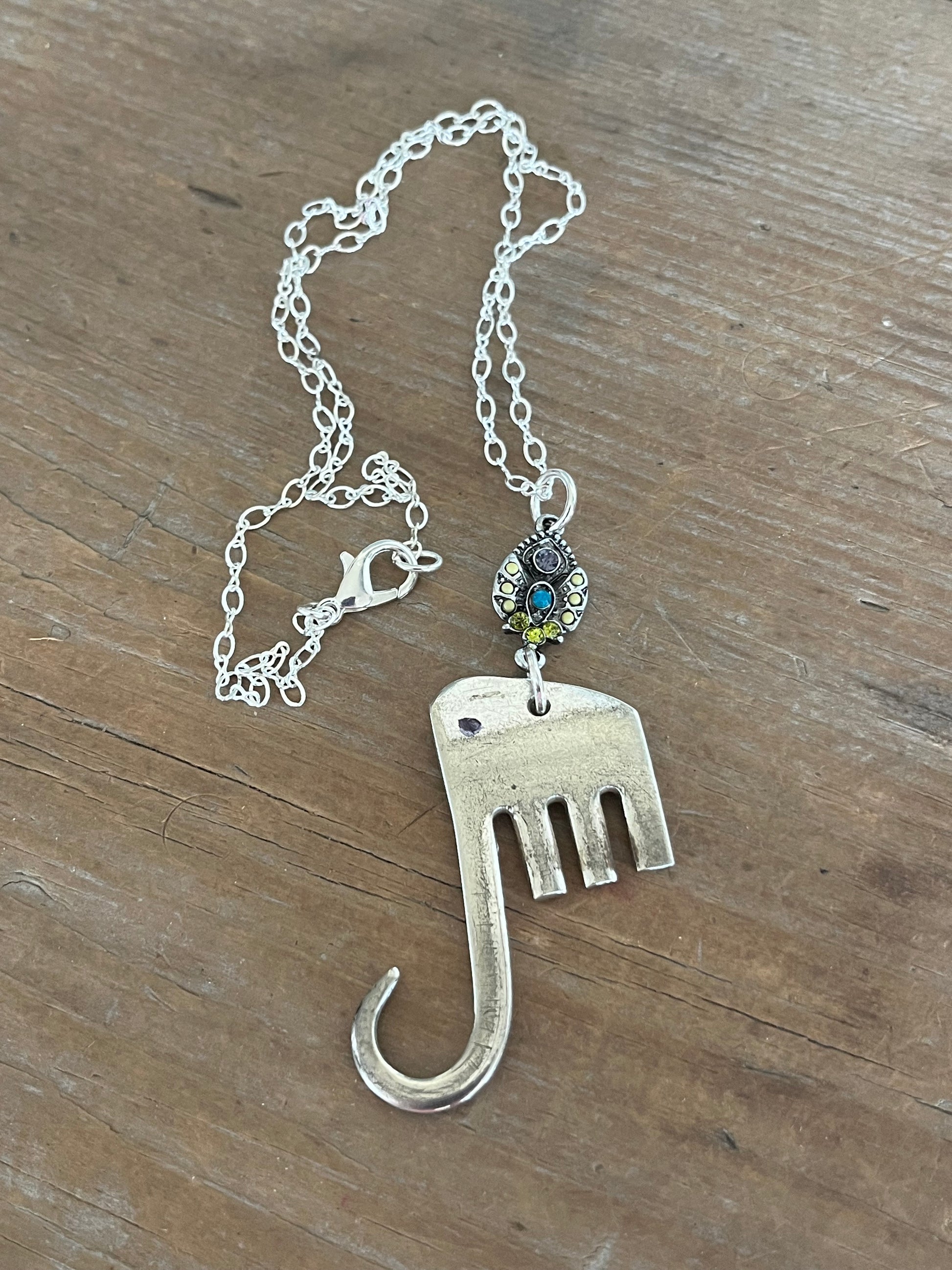 Fork elephant necklace with multicolor rhinestone bead on wood background showing full chain - handcrafted from upcycled vintage silverware - Laughing Frog Studio