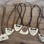 VOTE hand-stamped vintage spoon necklace shown with other Laughing Frog Studio hand-stamped silverware VOTE necklace designs on weathered wood - upcycled silverware jewelry collection - handcrafted from upcycled vintage silverware - Laughing Frog Studio