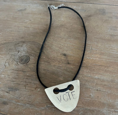 VOTE hand-stamped vintage spoon necklace on weathered wood showing full pendant and black faux suede cord with metal clasp - upcycled silverware spoon necklace - handcrafted from upcycled vintage silverware - Laughing Frog Studio