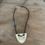 VOTE hand-stamped vintage spoon necklace on wood table showing full pendant and black faux suede cord with adjustable metal clasp - upcycled silverware spoon necklace - handcrafted from upcycled vintage silverware - Laughing Frog Studio