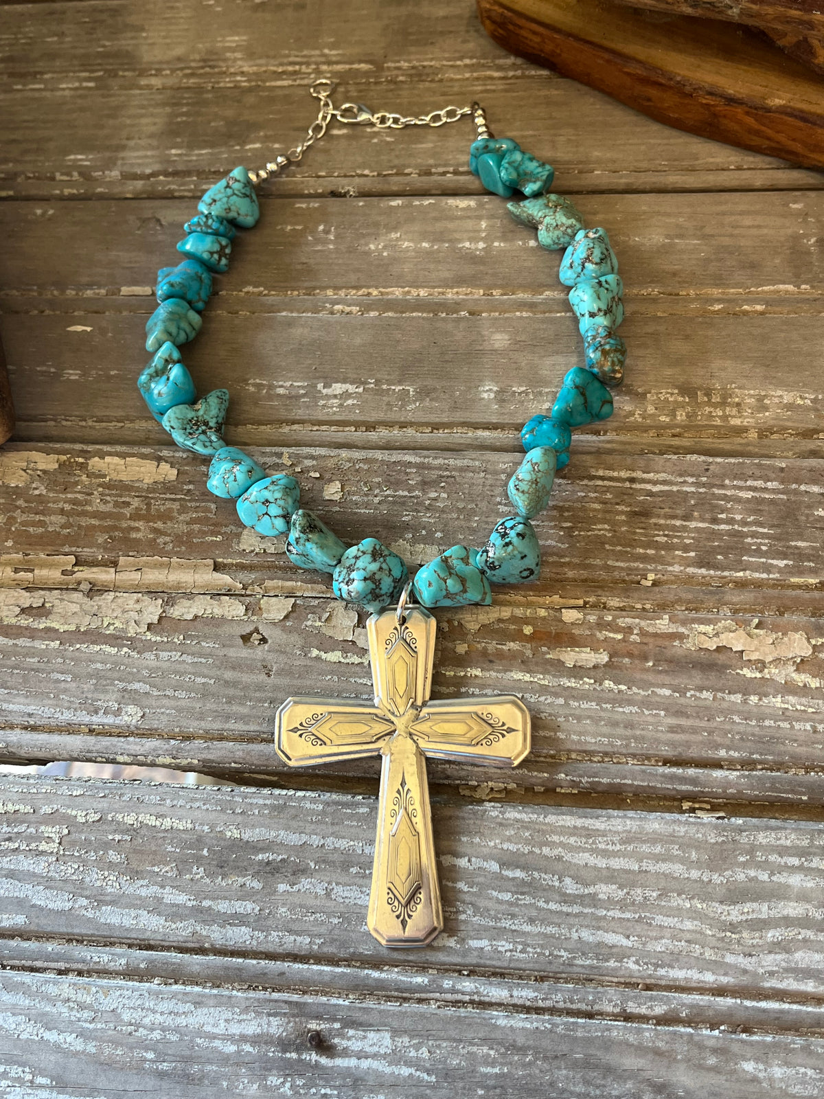 NUART cross with turquoise howlite beads and extender chain laid flat on wood - Spoon cross necklace - handcrafted from upcycled vintage silverware - Laughing Frog Studio