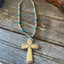 Full silverplate bead choker with turquoise-colored accent beads, spoon cross pendant, and clasp, laid flat on wood.