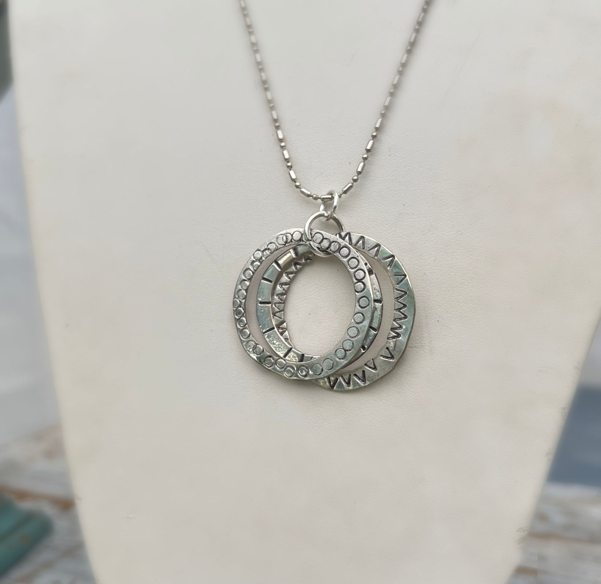 Close up of stamping detail on hand-stamped kinetic triple spoon necklace with movement rings - Spoon Necklace - handcrafted from upcycled vintage silverware - Laughing Frog Studio