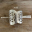 Cake server hair barrette detail view showing punched filigree pattern and craftsmanship