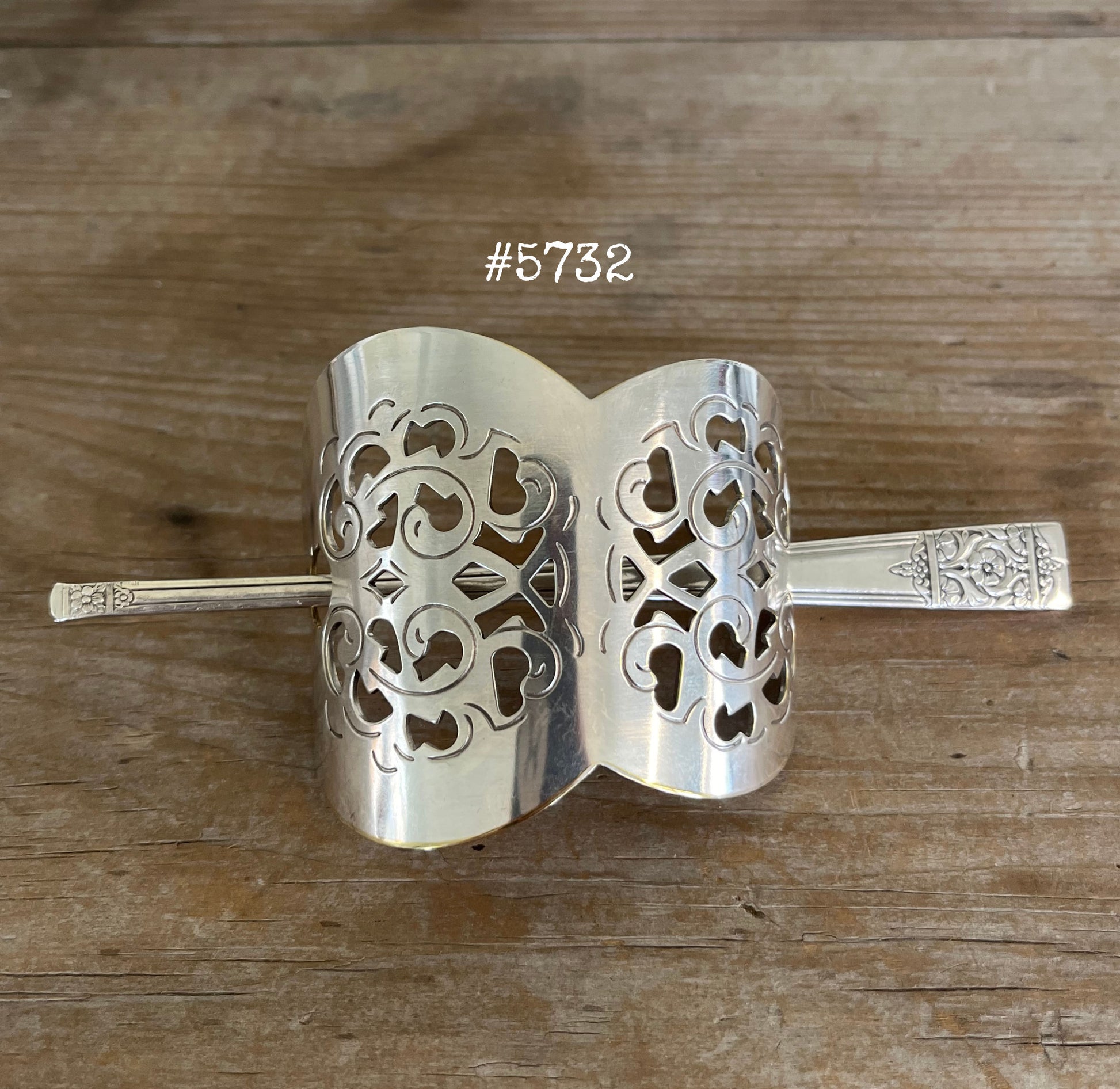 Cake server hair barrette detail view showing punched filigree pattern and craftsmanship