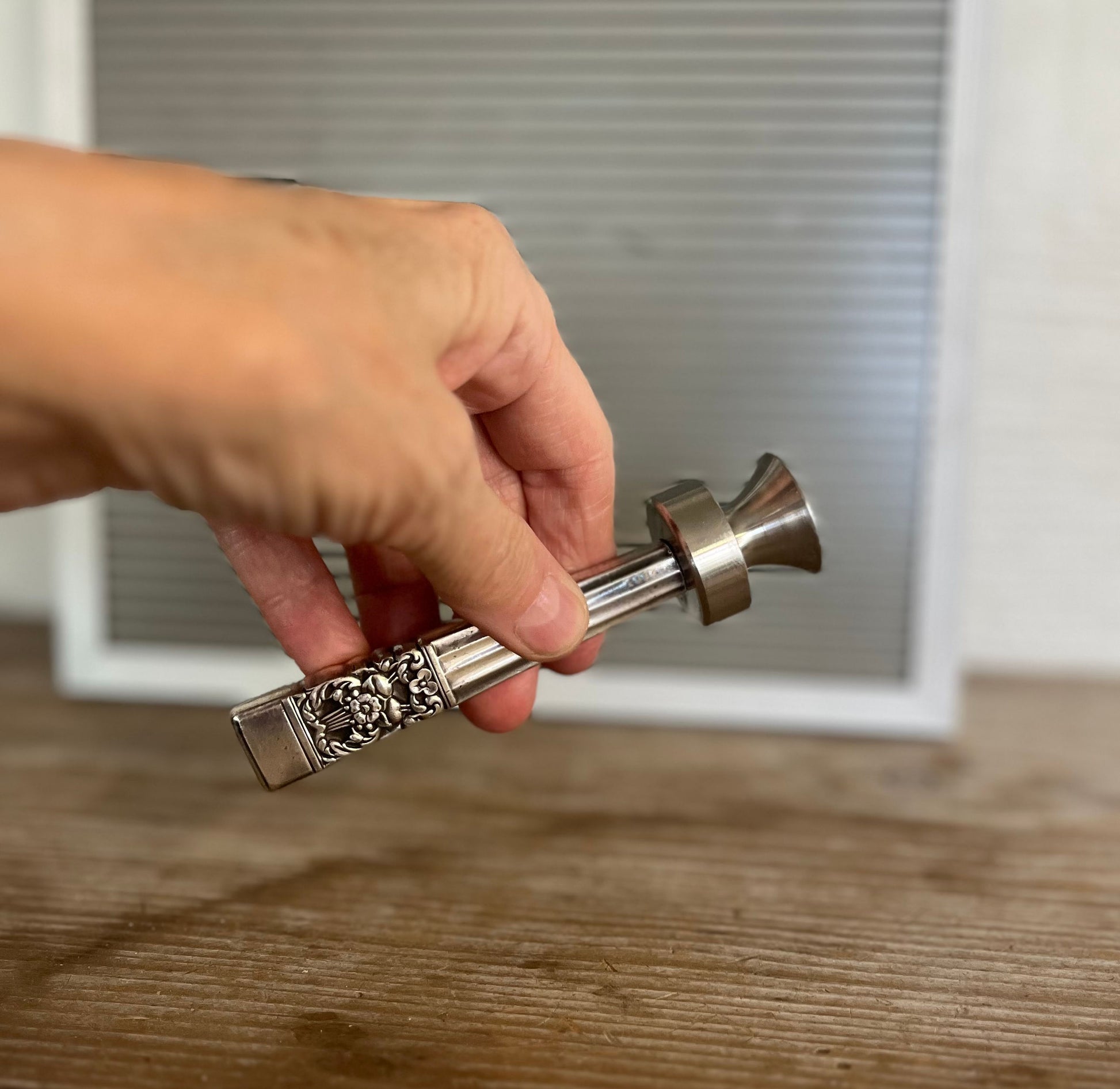 Coronation knife handle bottle opener with art deco design - handcrafted upcycled vintage silverware bar tool - shown in hand for size and scale