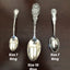 Three silver spoons with decorative handles on a dark brown background