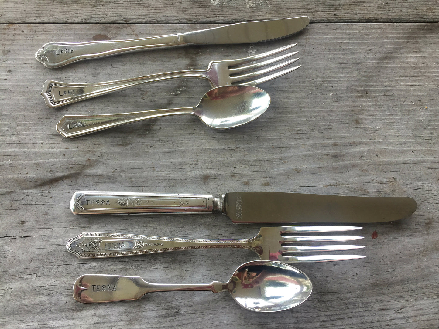 Rows of mixed vintage hand-stamped custom silverplate flatware sets with knives forks and spoons flat lay on wood - vintage silverware - handcrafted from upcycled vintage silverware - Laughing Frog Studio