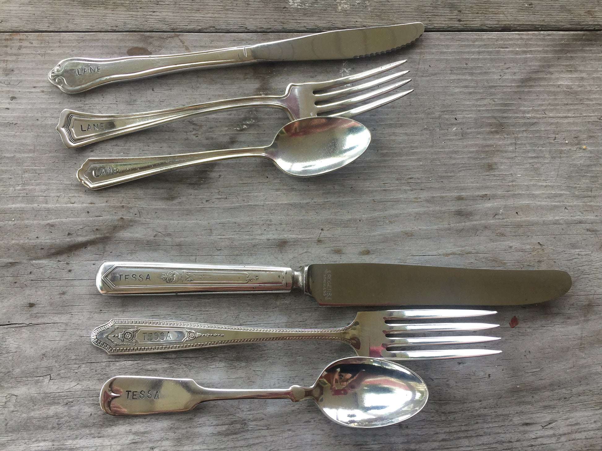 Rows of mixed vintage hand-stamped custom silverplate flatware sets with knives forks and spoons flat lay on wood - vintage silverware - handcrafted from upcycled vintage silverware - Laughing Frog Studio