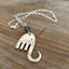 Close-up detail of handcrafted fork elephant pendant with aqua Czech glass bead, one-of-a-kind design