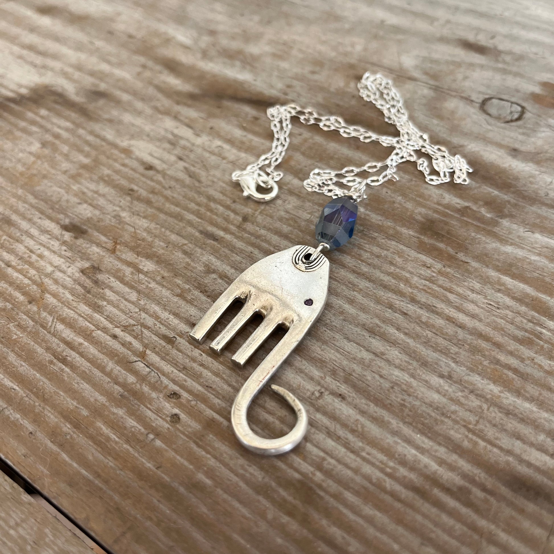 Close-up detail of handcrafted fork elephant pendant with smoky blue bead, 1.75 inches tall