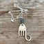 Upcycled silverplate fork elephant necklace with smoky blue faceted glass bead on 23-inch chain