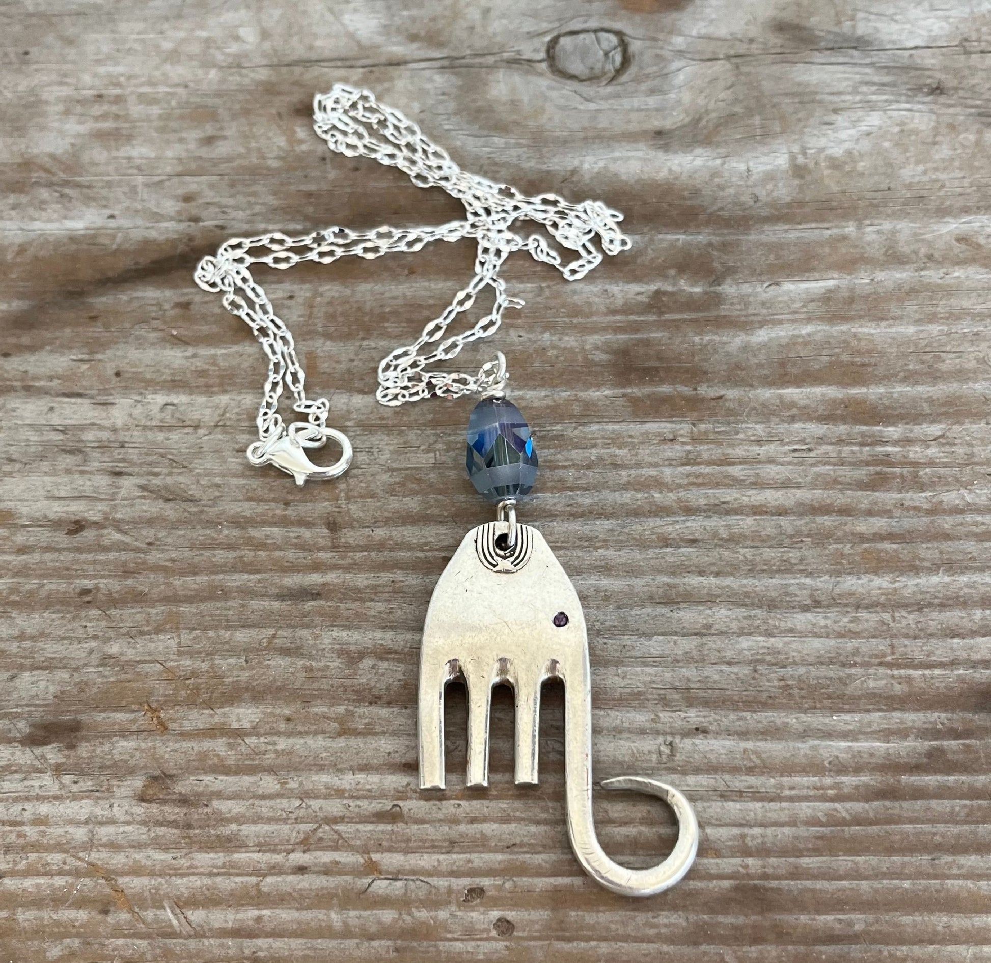 Upcycled silverplate fork elephant necklace with smoky blue faceted glass bead on 23-inch chain