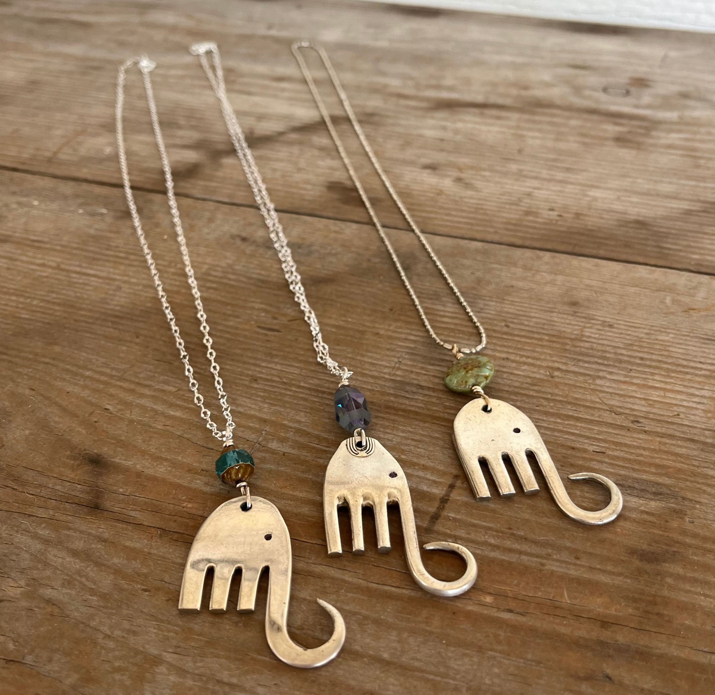 Trio of handcrafted fork elephant pendants showing variety of bead colors and shapes