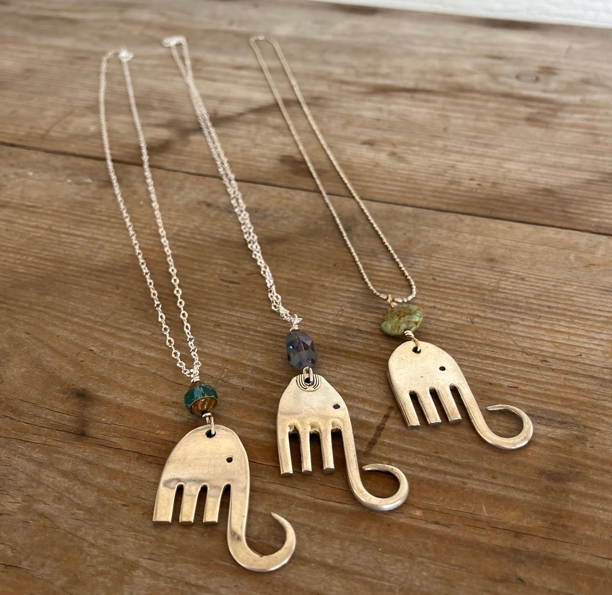 Trio of handcrafted fork elephant pendants showing variety of bead colors and shapes