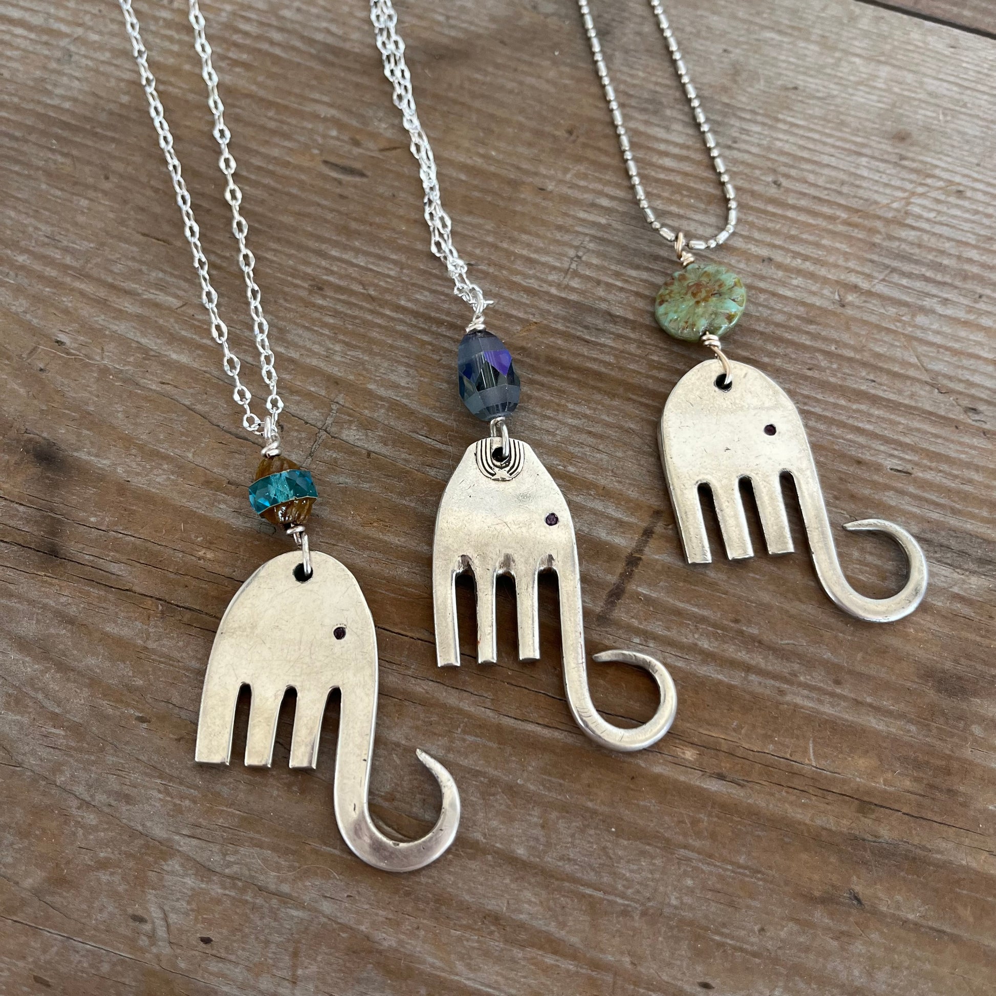 Trio of handcrafted fork elephant pendants showing variety of bead colors and body shapes