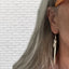 Fork tine earrings with owl charms modeled on ear displaying wearable fit and rebel energy style