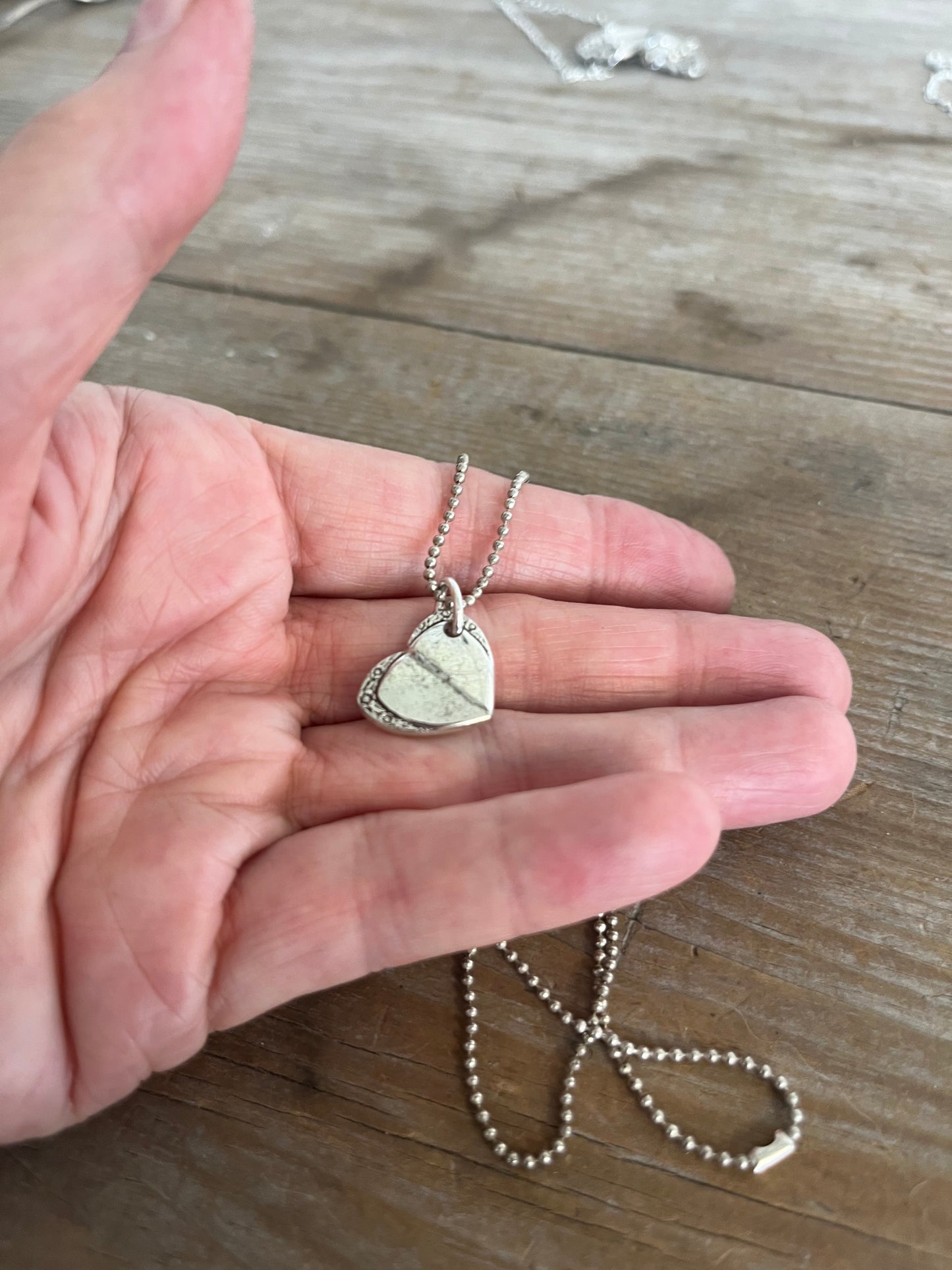 Close-up of MARY LOU fork heart pendant showing detailed silverware pattern and craftsmanship