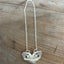 Close-up of Lovely Lady heart pendant showing intricate floral openwork pattern detail on vintage silverplate necklace