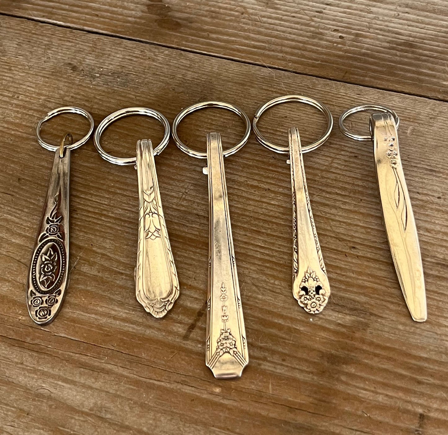Vintage spoon handle keychains handcrafted from upcycled antique silverware multiple patterns displayed