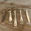 Detailed view of vintage spoon handle keychains showing upcycled silverware patterns and ornate details