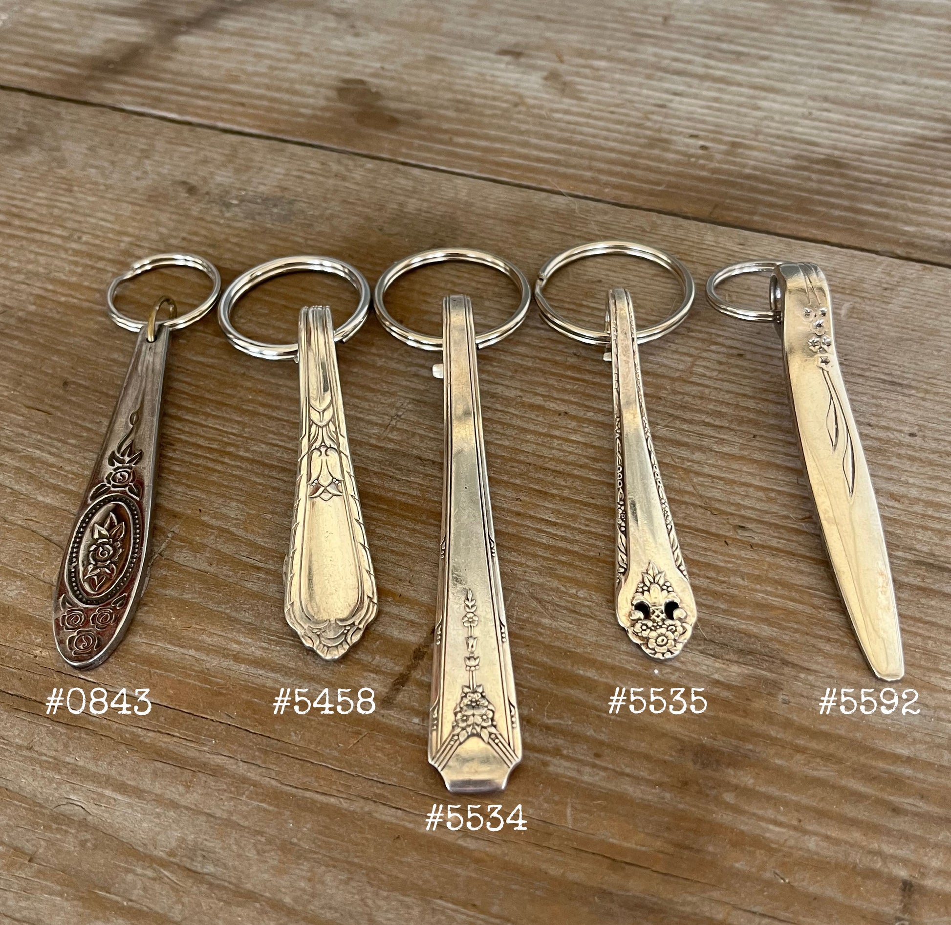 Detailed view of vintage spoon handle keychains showing upcycled silverware patterns and ornate details