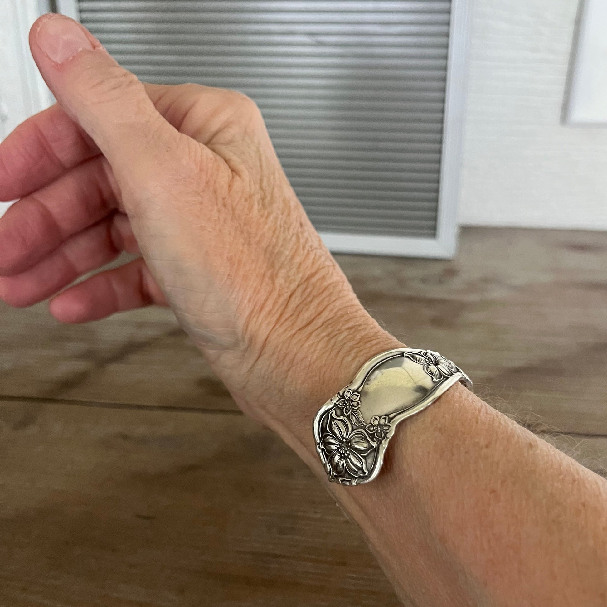 Orange Blossom spoon cuff bracelet shown on model wrist - vintage 1910 silverplate with flowing botanical details