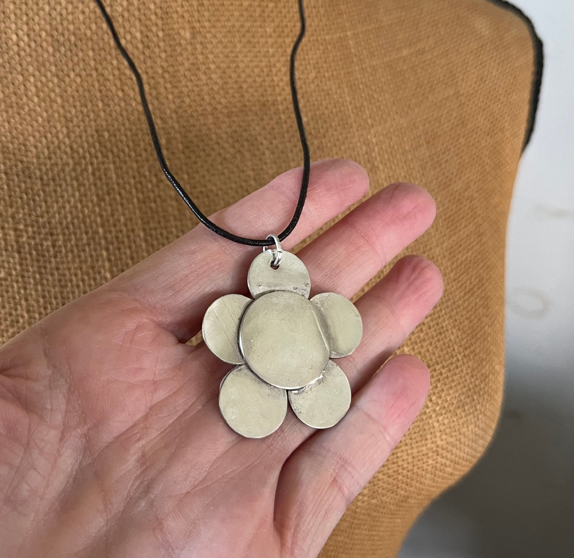Vintage silverplate daisy spoon necklace on leather cord shown in hand for scale - Spoon Necklace - handcrafted from upcycled vintage silverware - Laughing Frog Studio