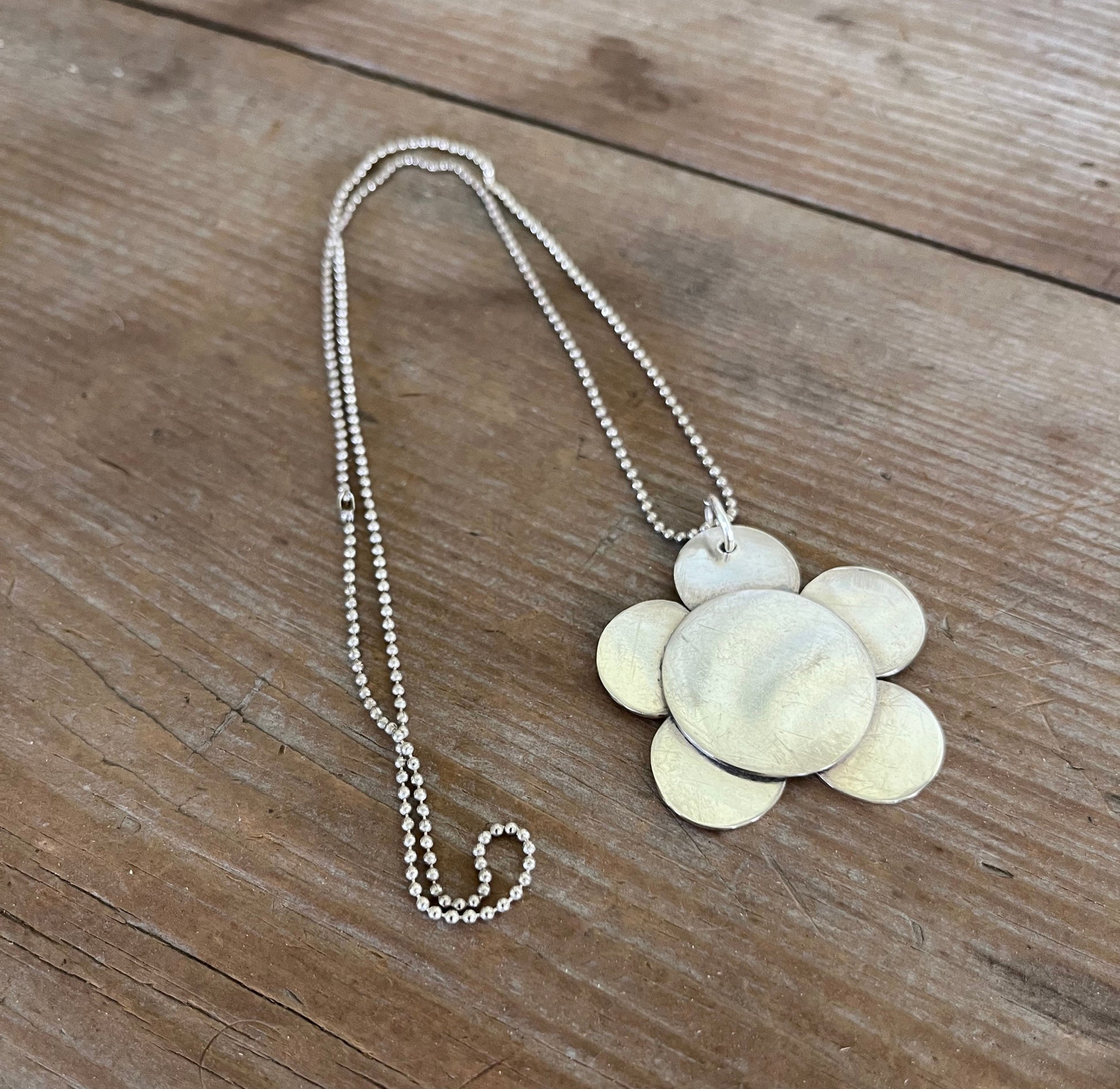 Flat lay of vintage silverplate daisy spoon necklace on ball chain - Spoon Necklace - handcrafted from upcycled vintage silverware - Laughing Frog Studio