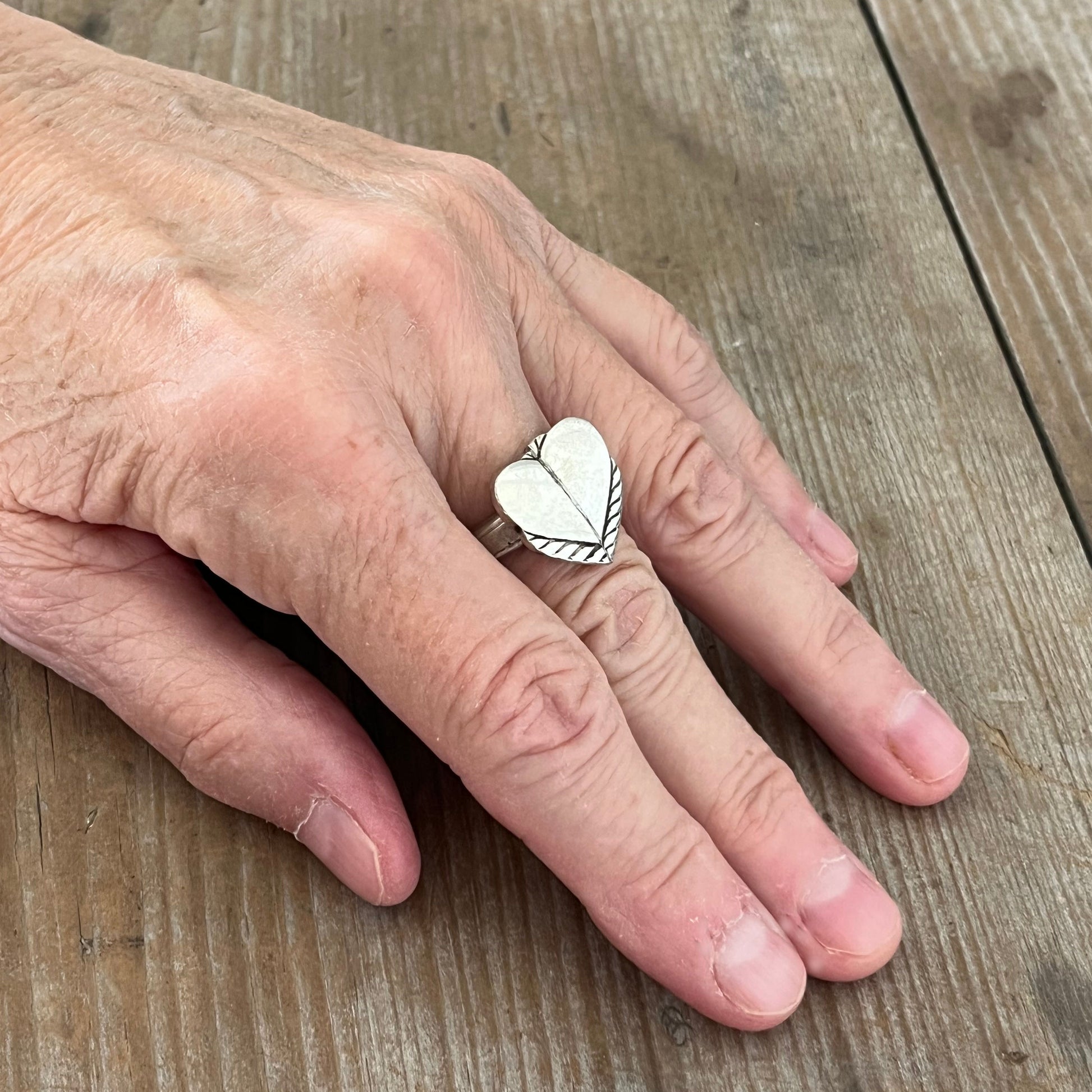 Artisan heart spoon ring featuring vintage silverplate spoon handles shown on a hand