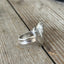 Side detail view of three-piece construction on heart spoon ring with vintage silverplate handles