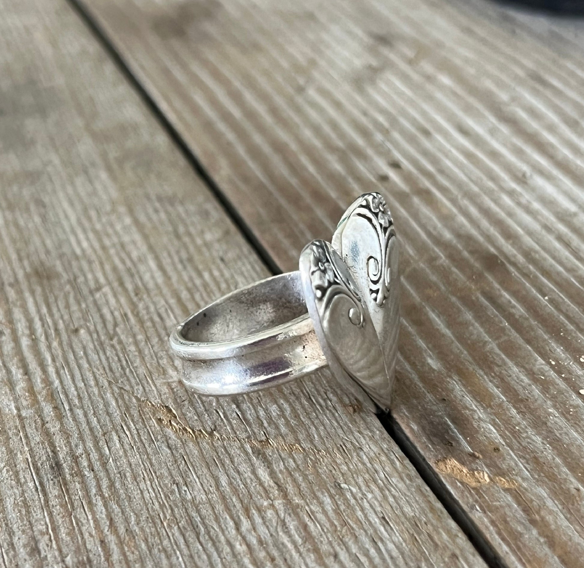 Side detail view of three-piece construction on heart spoon ring with vintage silverplate handles