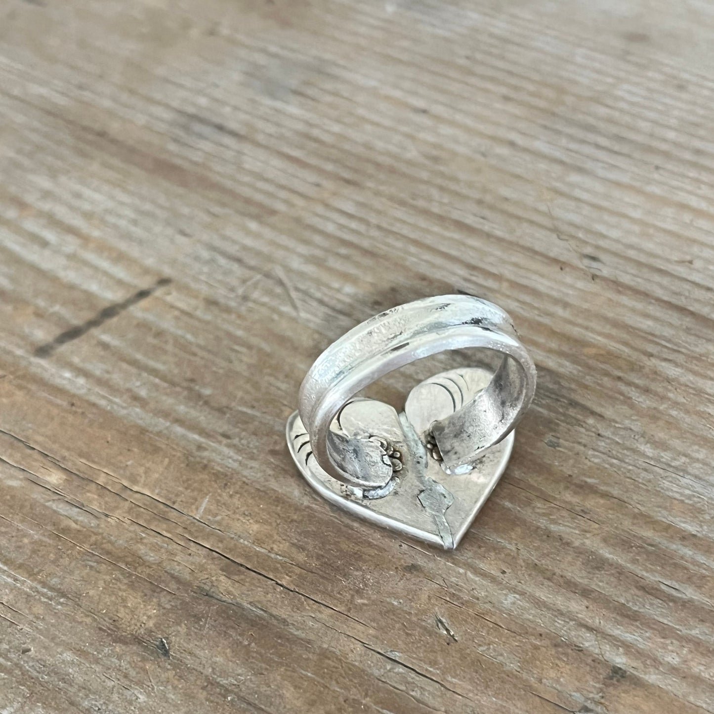 Detail of three-piece construction on heart spoon ring with vintage silverplate handles