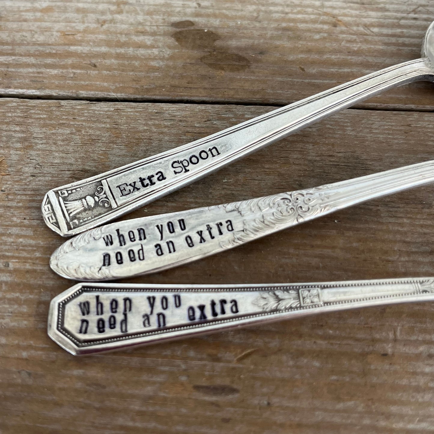 Close-up of hand-stamped Extra Spoon text on vintage silverplate spoon handles