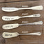 Collection of antique silverware spreaders stamped with Spread Joy message for charcuterie boards
