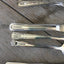 Close-up of hand-stamped personalization on vintage silverplate cutlery set