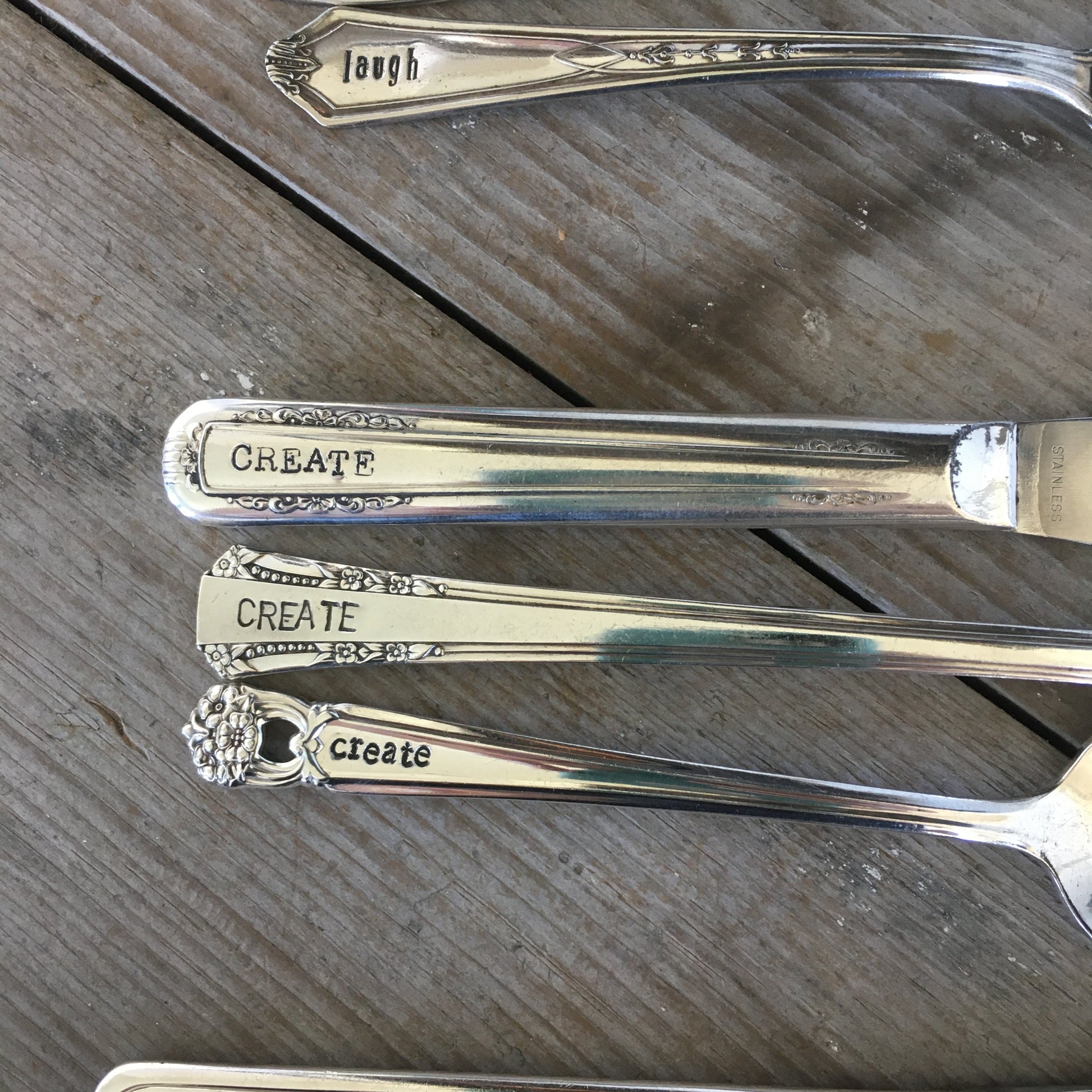 Close-up of hand-stamped personalization on vintage silverplate cutlery set