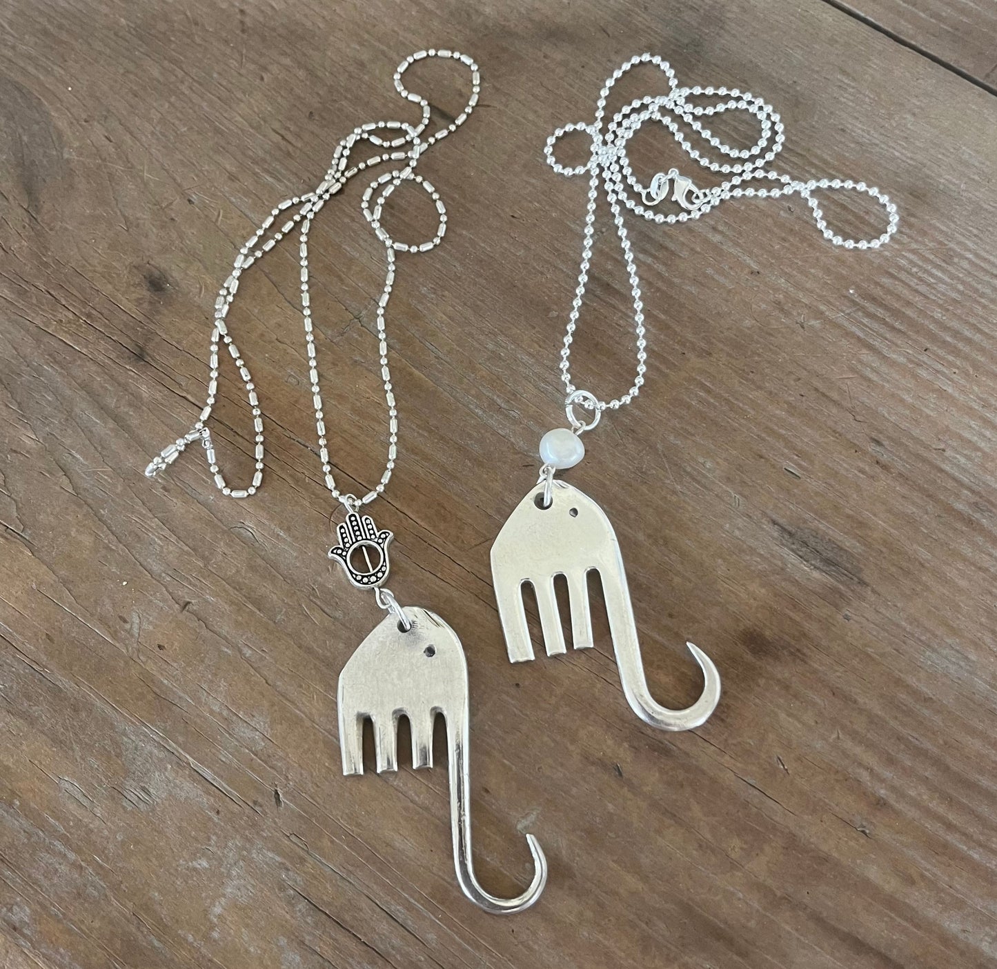 Two fork elephant necklaces side by side showing Hamsa and pearl bead variations - handcrafted from upcycled vintage silverware - Laughing Frog Studio