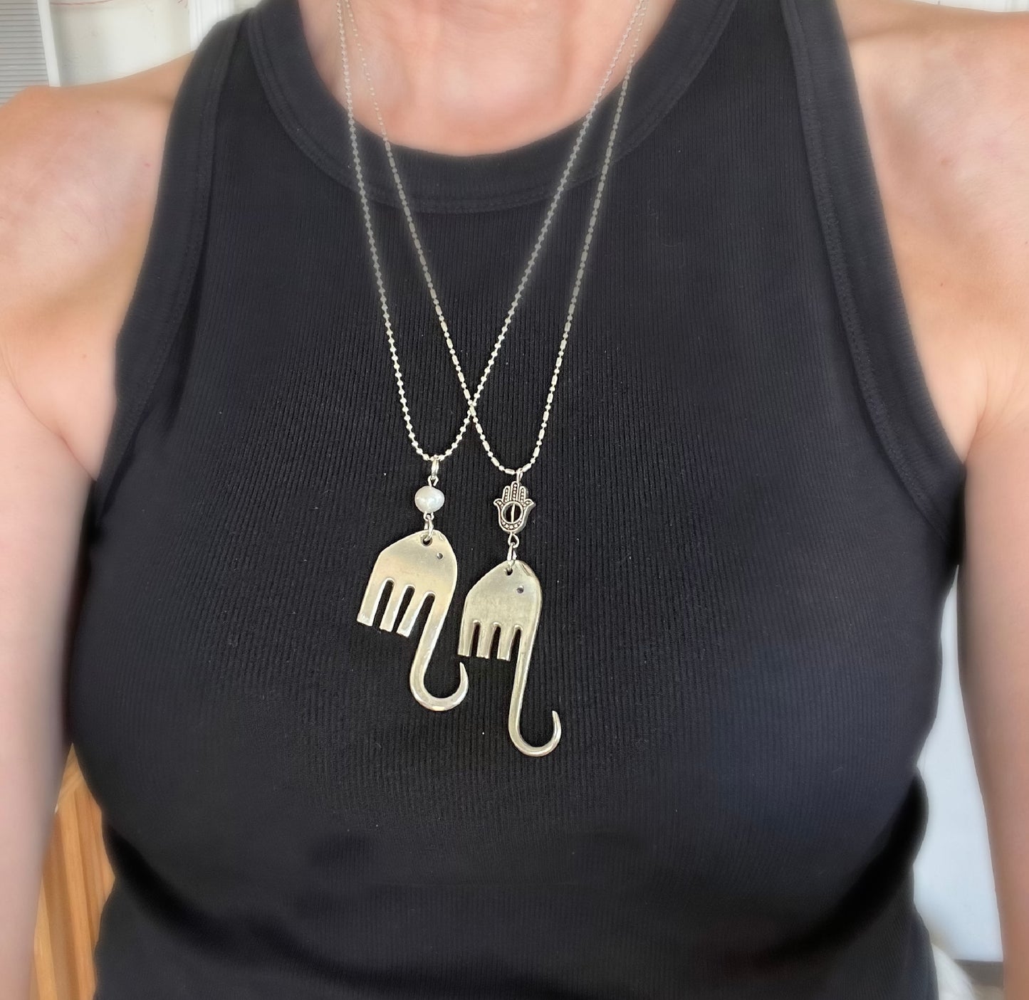 Two fork elephant necklaces worn together on model showing Hamsa and pearl bead styles layered - handcrafted from upcycled vintage silverware - Laughing Frog Studio