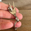 Handmade peace sign fork keychain shown in hand for scale - upcycled vintage silverware accessory - Laughing Frog Studio
