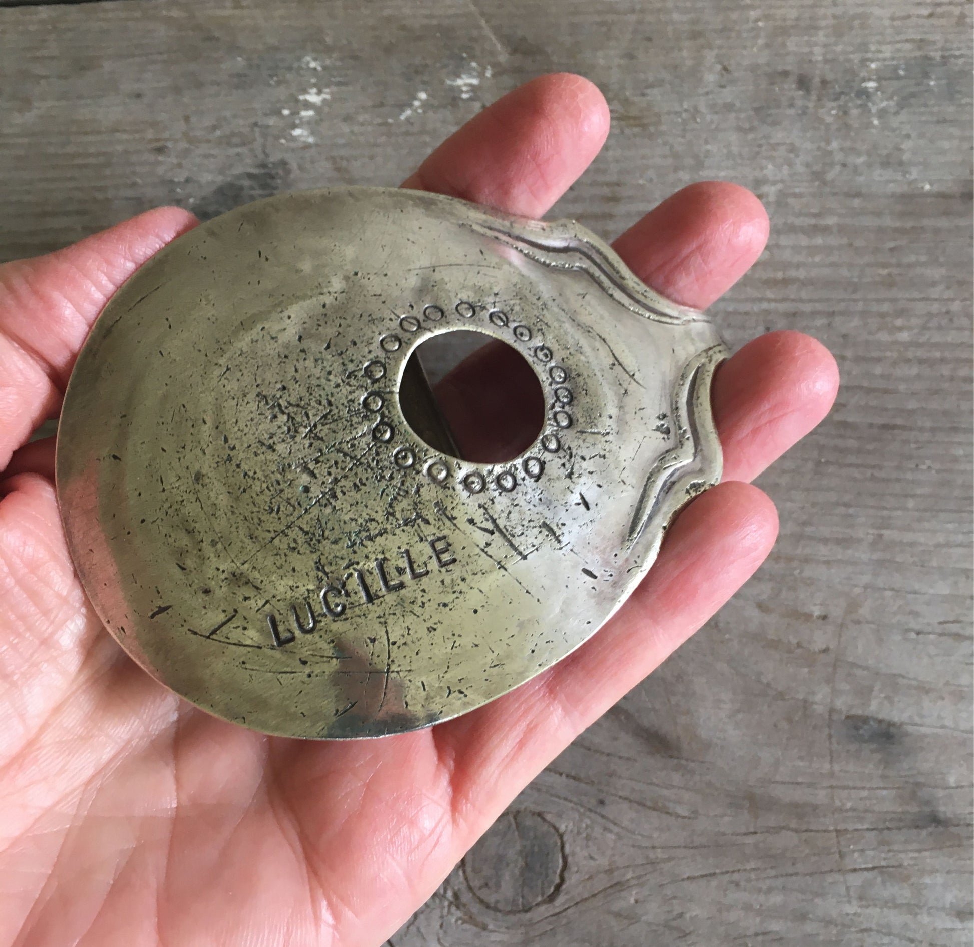 Guitar Belt Buckle Stamped Lucille shown in hand for scale