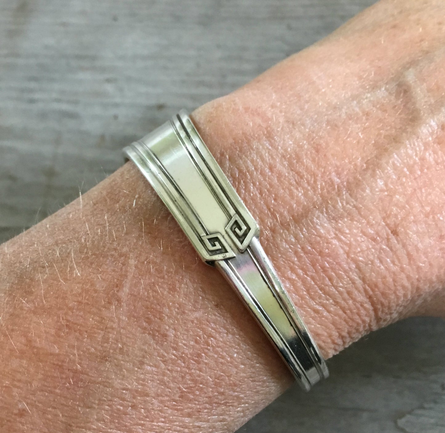 1881 Rogers Grecian pattern spoon cuff bracelet worn on wrist - handcrafted from upcycled vintage silverware - Laughing Frog Studio