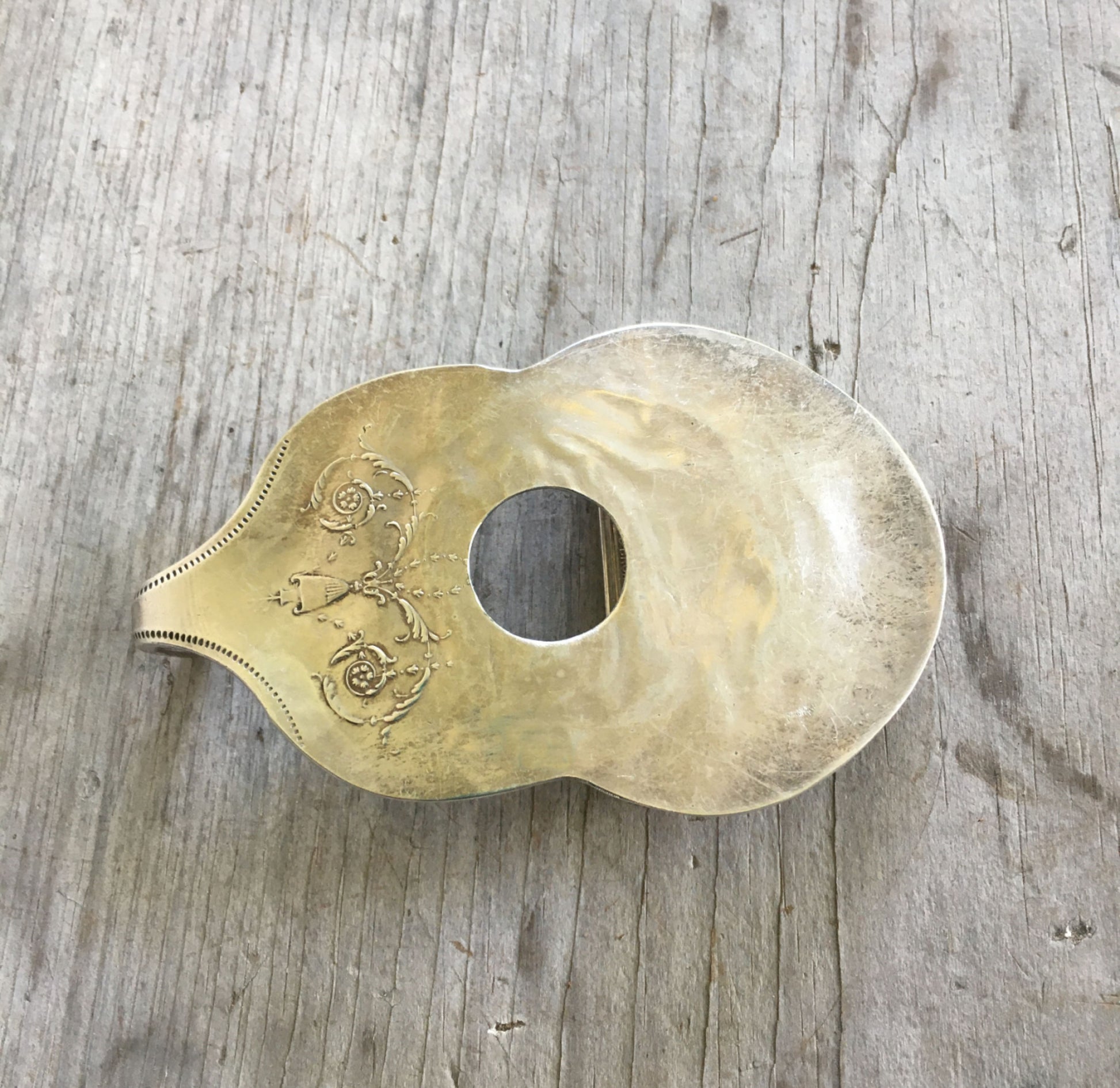 Handcrafted guitar-shaped spoon belt buckle made from upcycled 1921 Community Silverplate Grosvenor casserole spoon with drilled sound hole, fits 2-inch belt