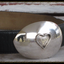 Side angle of heart spoon belt buckle showing dimensional fork-tine heart and vintage silverware pattern detail on casserole spoon
